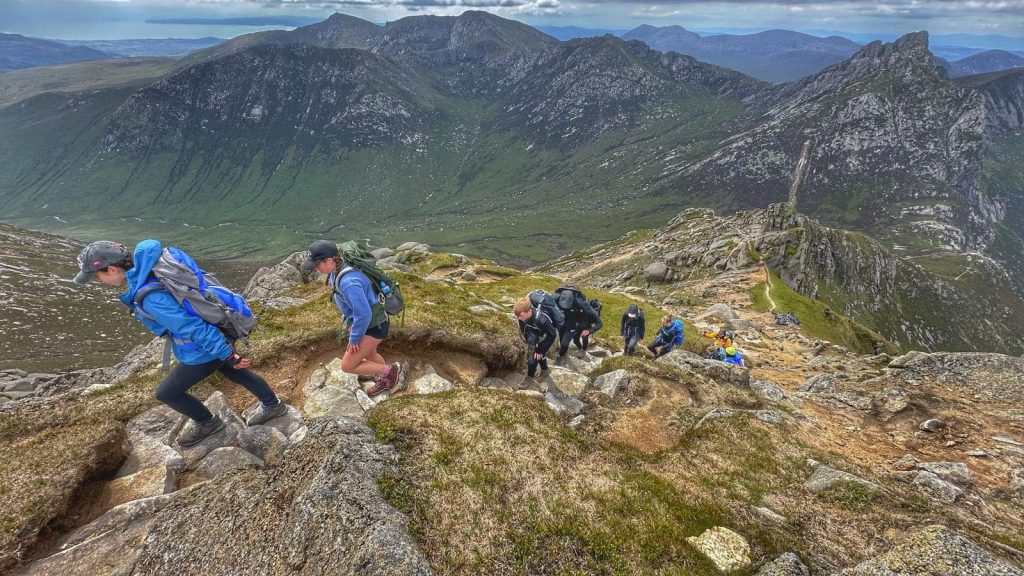 young people hiking on a rocky trail