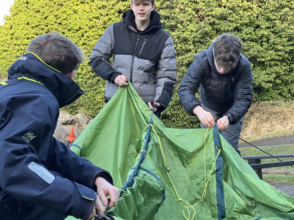 three boys set up a tent